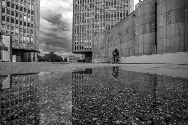 Ljubljana-Republic-square-ex-Revolution-square-ib-02 Man on bike and his reflection in front of buildings at the republic square, Ljubljana. Photo by Iztok Boncina.