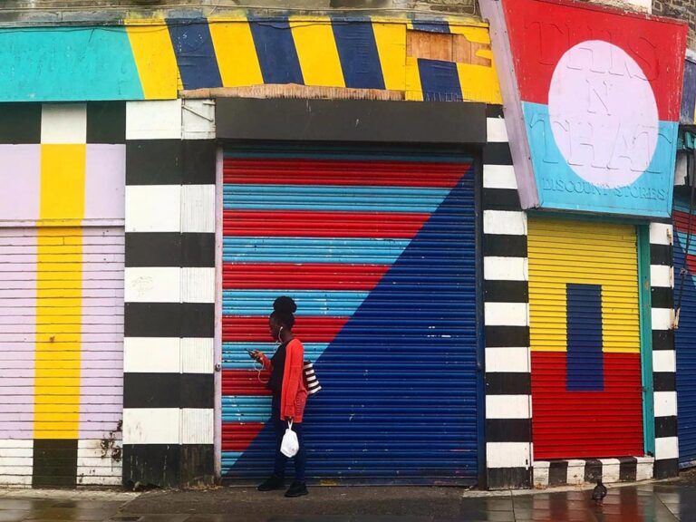 London-hackney-woman-colorful-storefront-AS Woman in front of colorful storefreont in Hackney London. Photography by Ana Šesto
