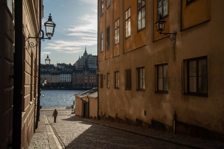 Stockholm-Sweden-Riddarholmen-ELJ-012 A pedestrian walks on a cobblestone street, at Riddarholmen, Stockholm, Sweden. Photo by Eva-Lotta Jansson